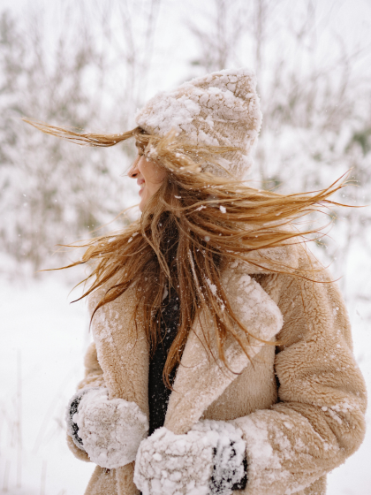 Frau im Schnee, dreht ihren Kopf und die Haare fliiiegen!